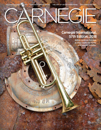 Cover of magazine showing a trumpet laying on top of a pile of rusted metal.