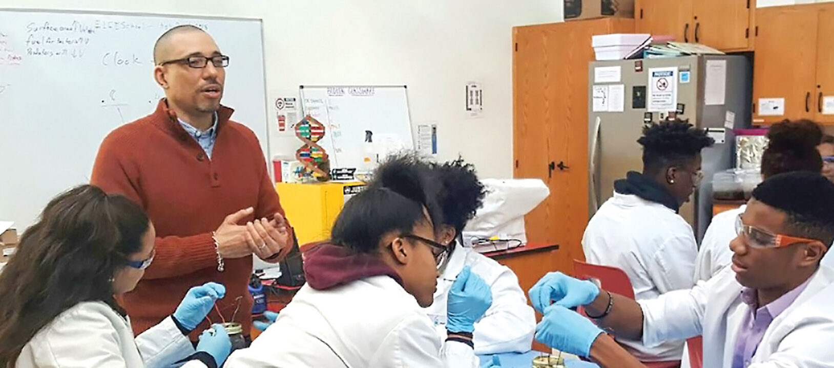 Andre Samuel leading a clas of young science students.