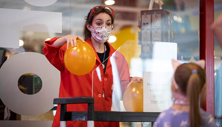 A member of CArnegie Science Center staff demonstrating to a group of children
