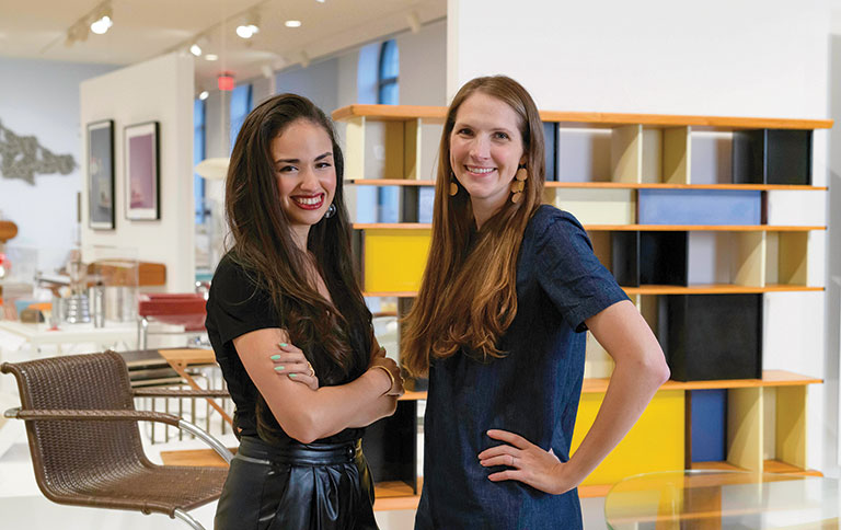 Two women standing side-by-side- in an art installation