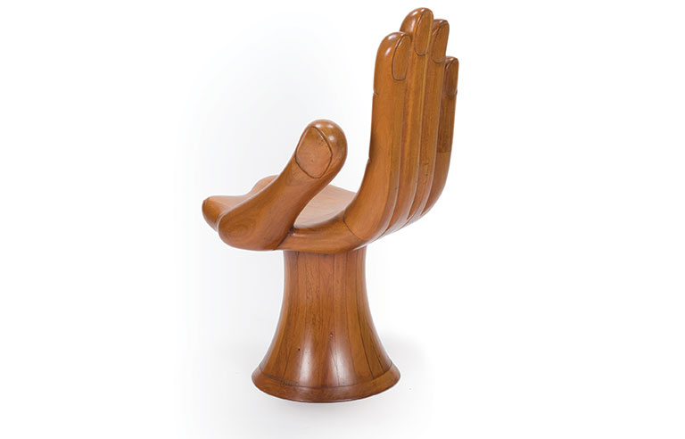 A large wooden chair in the shape of a hand