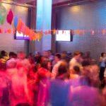 A blurred image of a group of teens dancing