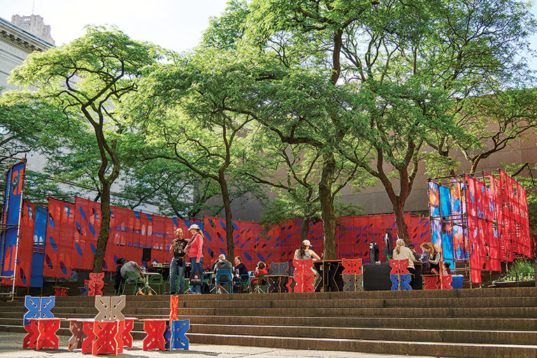 installation view of a colorful fabric over metal poles artwork