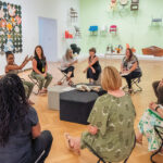 A group of teachers sitting in a circle, talking and laughing.