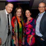 A group of four people posing for a photo at an event.