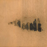 A large piece of artwork with abstract shapes printed in dark colors against a copper background.