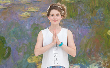A woman holding a yoga stance in front of artwork in a gallery