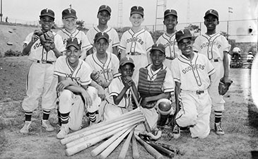 A black and white photo group of youg boys posing in their baseball uniforms