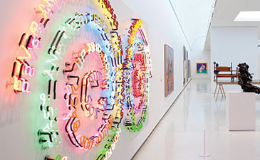 An gallery installation view of a colorful neon artwork