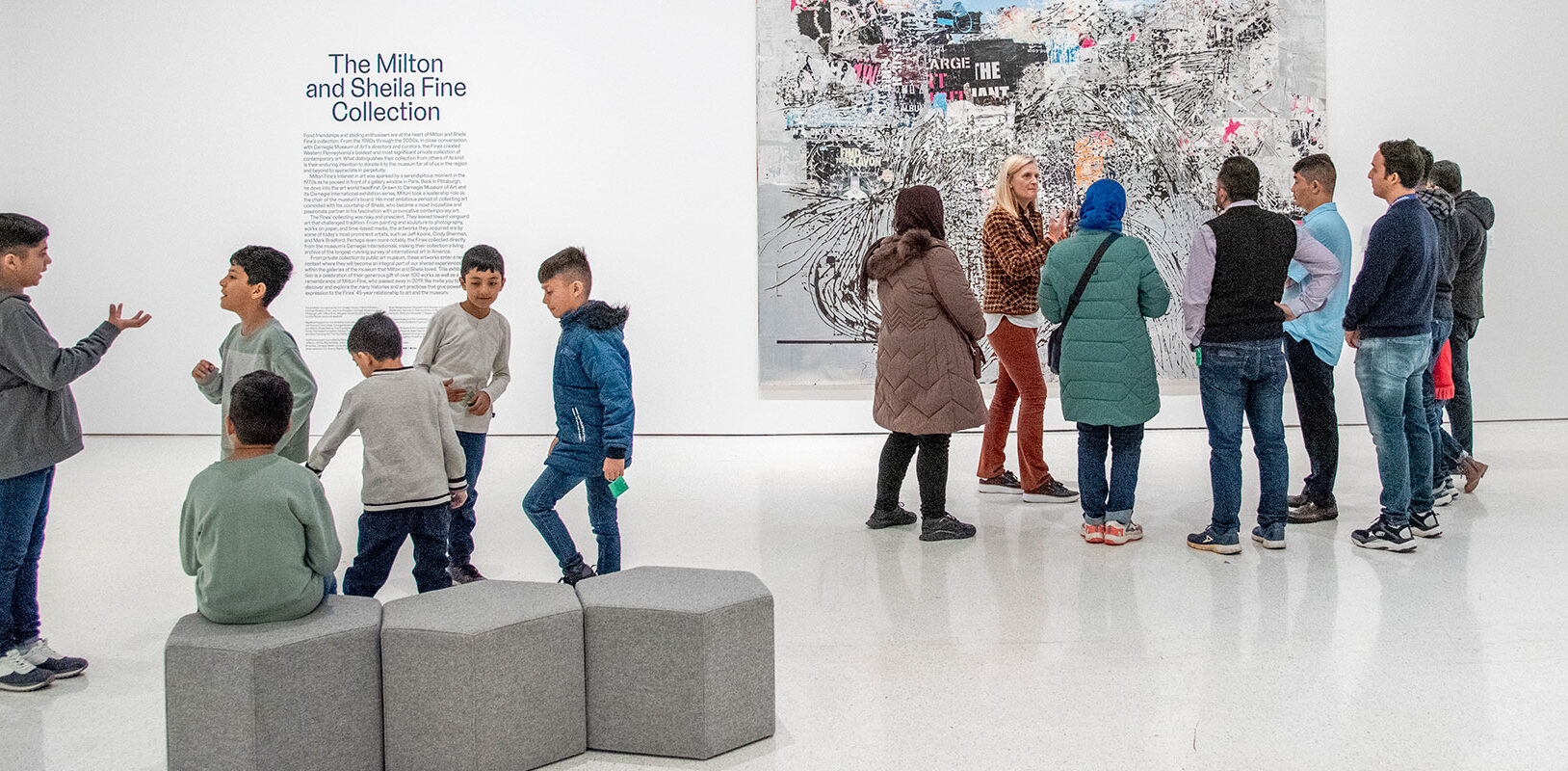 An art museum educator leading a tour of immigrant families through the museum.