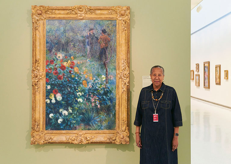 A female volunteer standing next to a large piece of artwork