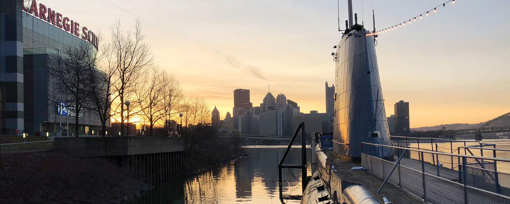 Evening sunset view of a submarine with the city of Pittsburgh in the distance