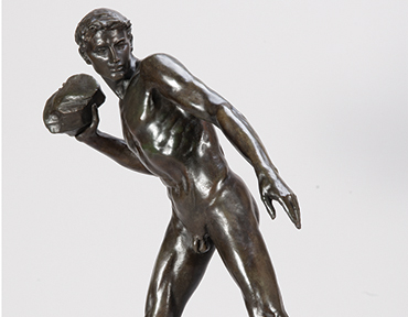 a sculture of a naked man throwing a stone