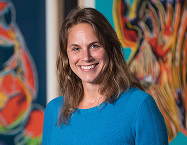 Portrait of Nicole Heller standing in front of Andy Warhol's Endangered Species paintings