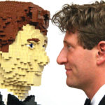The artist facing to face with a replica of himself made from lego bricks.
