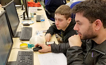 A teen and a mentor working on a project.