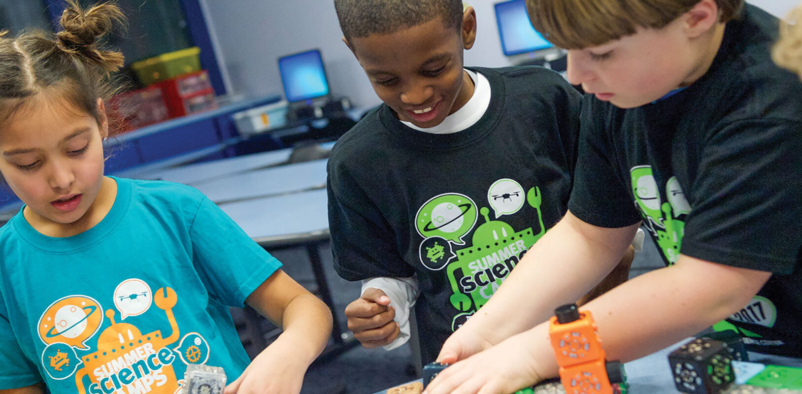 A group of children laughing and working on a science project