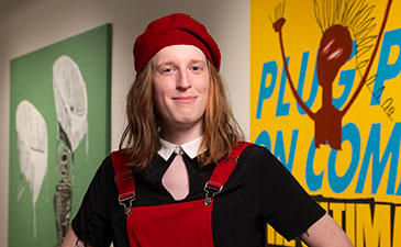 A portrait of Scottie FLora standingin front of artwork at the Warhol Museum