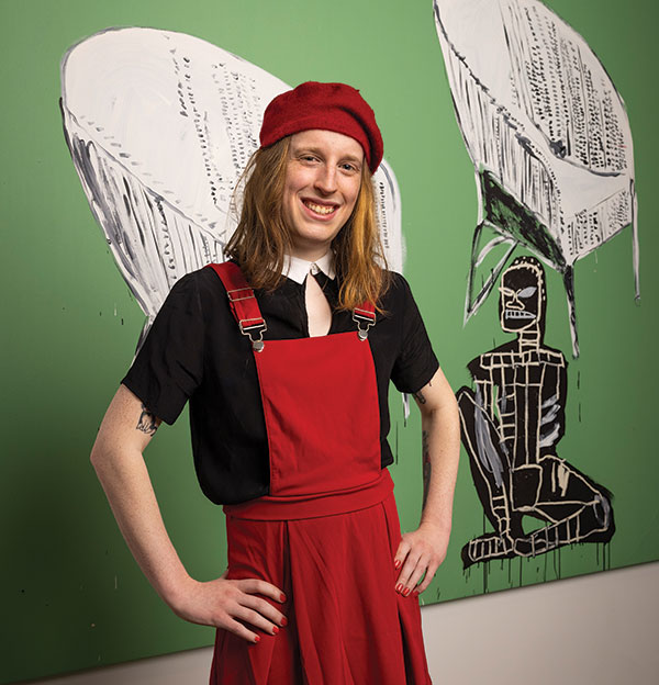 A portrait of Scottie FLora standingin front of artwork at the Warhol Museum