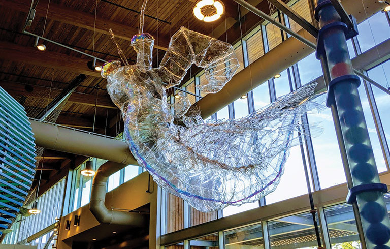 A plastic sculpture hangin in a warehouse setting