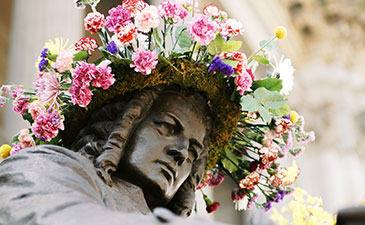 A sculpture of Bach with a wreath of flowers on his head
