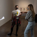 A gallery assistant at the Warhol museum speaking with a museum visitor