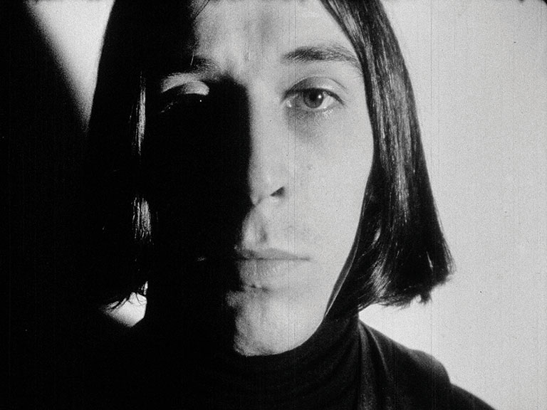 Black and white film still of John Cale