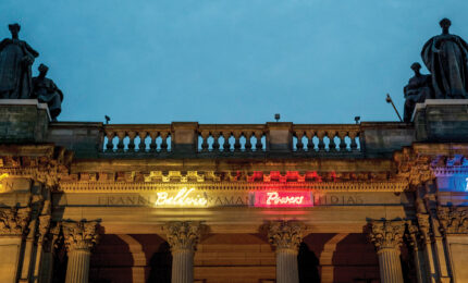 An exterior view of the museum showing the neon names that wrap around the perimeter.