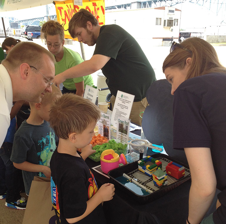 A man and his young son talking to a museum educator.
