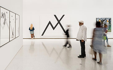 People viewing an exhibit in the art museum.