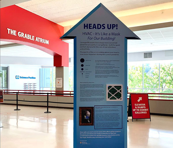 A sign shaped like an arrow that says Heads Up.