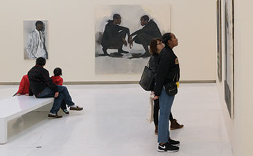 People in an art museum gallery looking at paintings