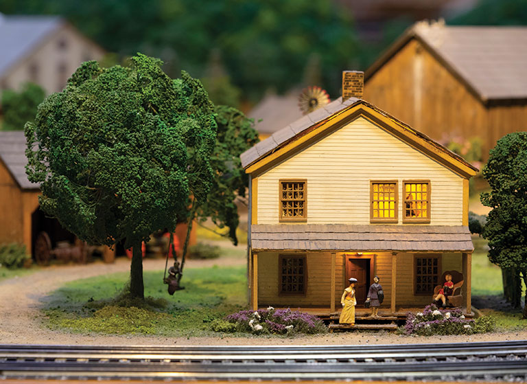 Miniature version of home with figures on the front porch