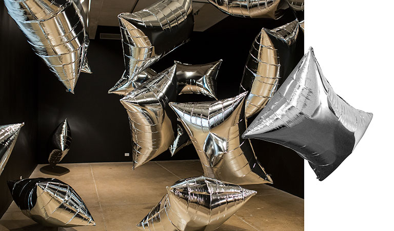 Metallic balloons floating in a dark room