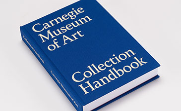 A blue book with Carnegie Museum of Art Collection Handbook on the cover