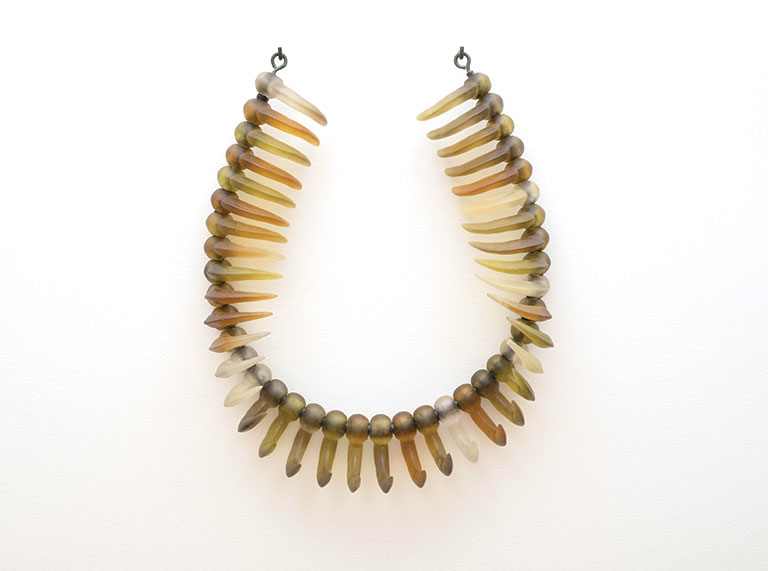 A large glass knecklace hanging on a wall