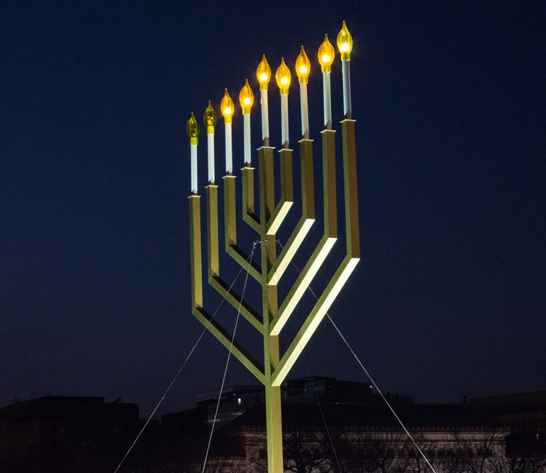 A large menorah lit against a dark sky in Washington DC