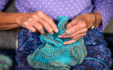 The hands of an elderly woman crocheting