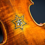 A violin with the star of David inlaid on the back of it.