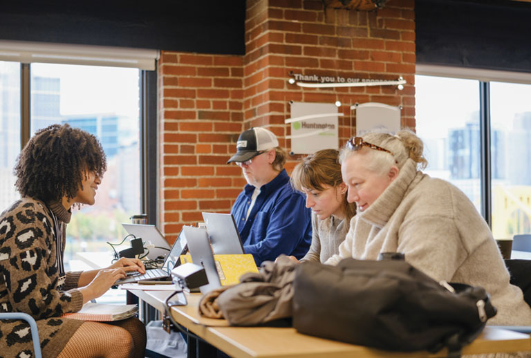 A group of adult students working on their computers.